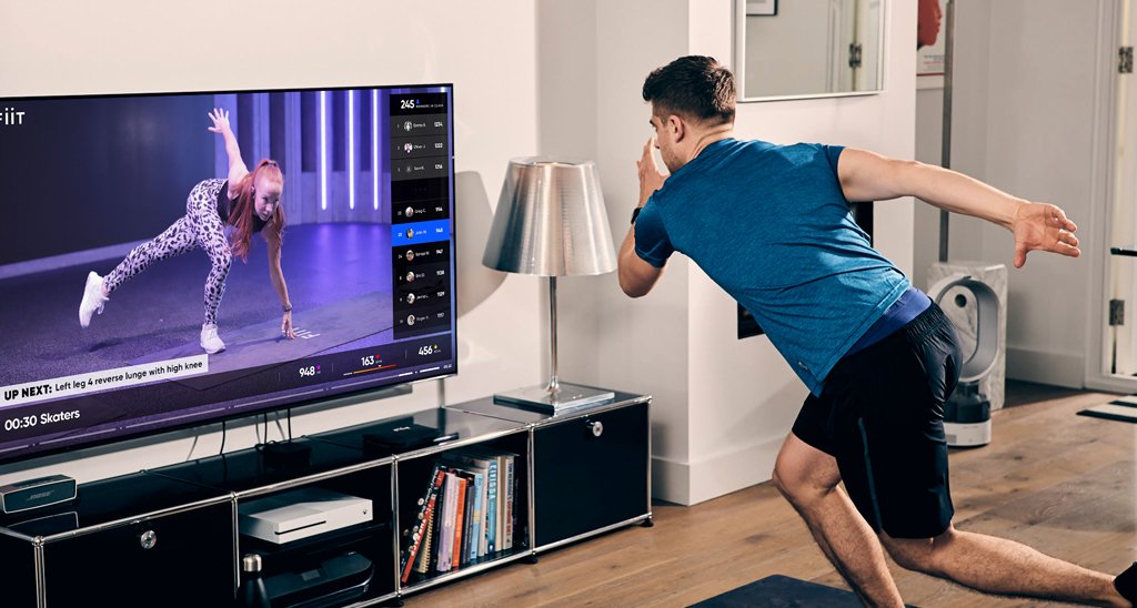 A man using an on-demand fitness platform to workout at home