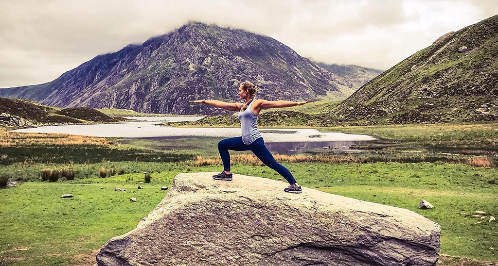 HFE graduate Aneliese Foxwell performs the Warrior 2 yoga pose