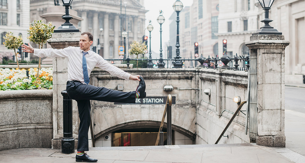 Creator of Yogibanker Scott Robinson performing a yoga pose in a suit